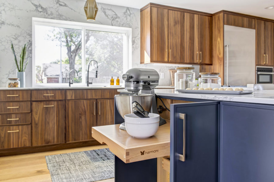 A stand-up mixer in built-in storage of a kitchen isalnd